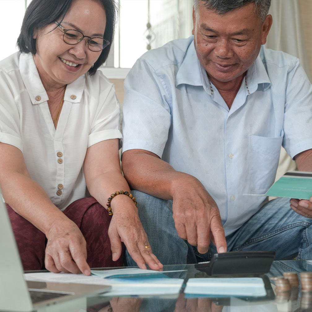 couple sitting on couch going over financial paperwork will i have enough to retire holland oh